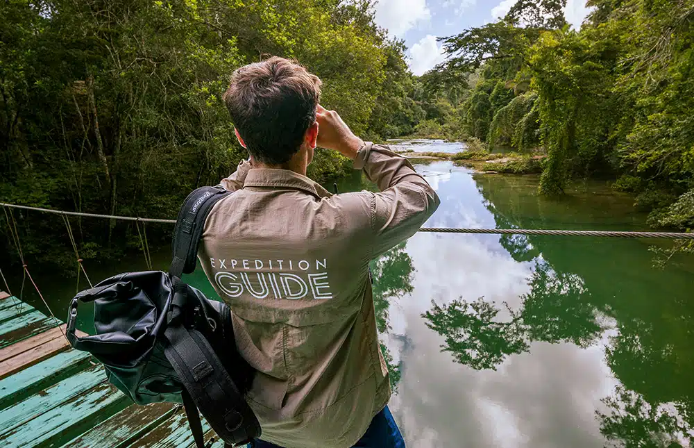 Guide naturaliste sur un pont - rivière tropicale